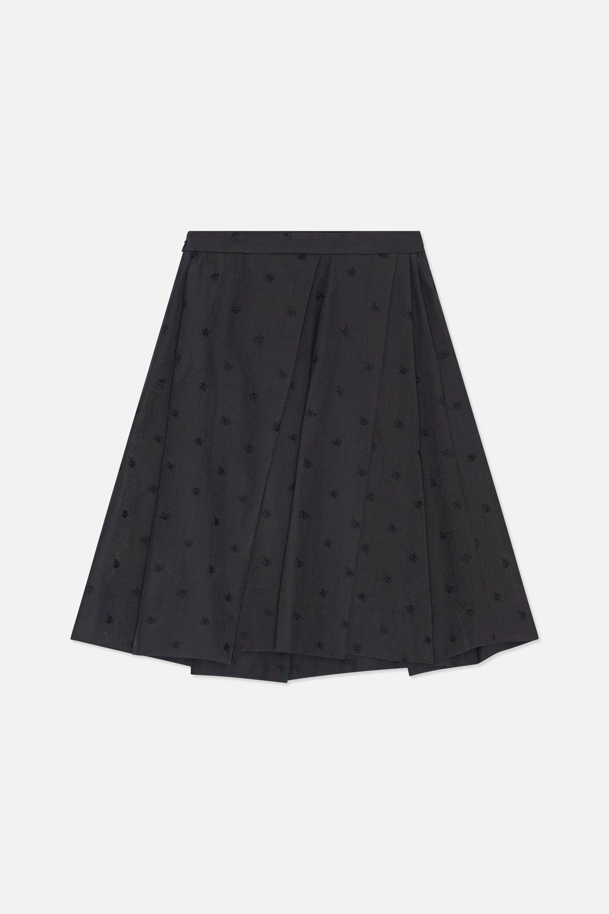 Framifrån i full längd: kolgrå plisserad midikjol med spridda svarta broderade motiv.