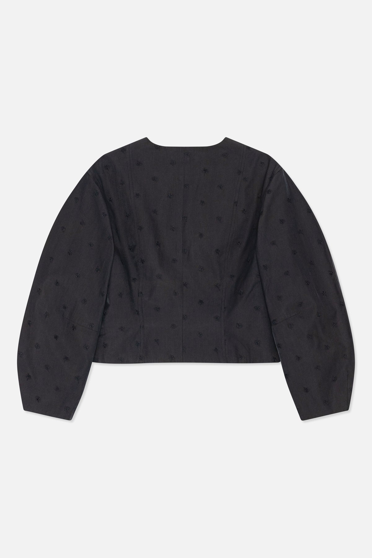 Bild bakifrån av en mörk kolgrå långärmad topp med vid halsringning, formade panelsömmar och spridda ton-i-ton blommotiv.